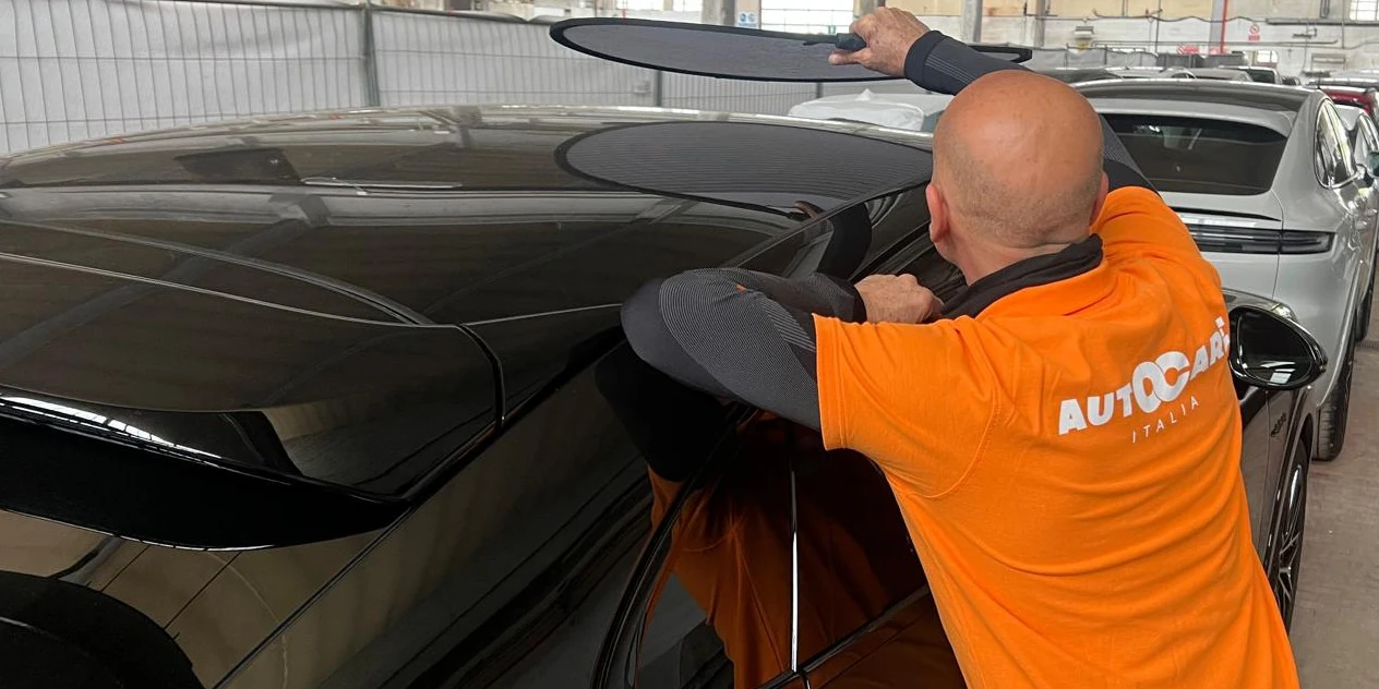 Tecnico Autocare al lavoro con il levabolli sulla fiancata di una vettura